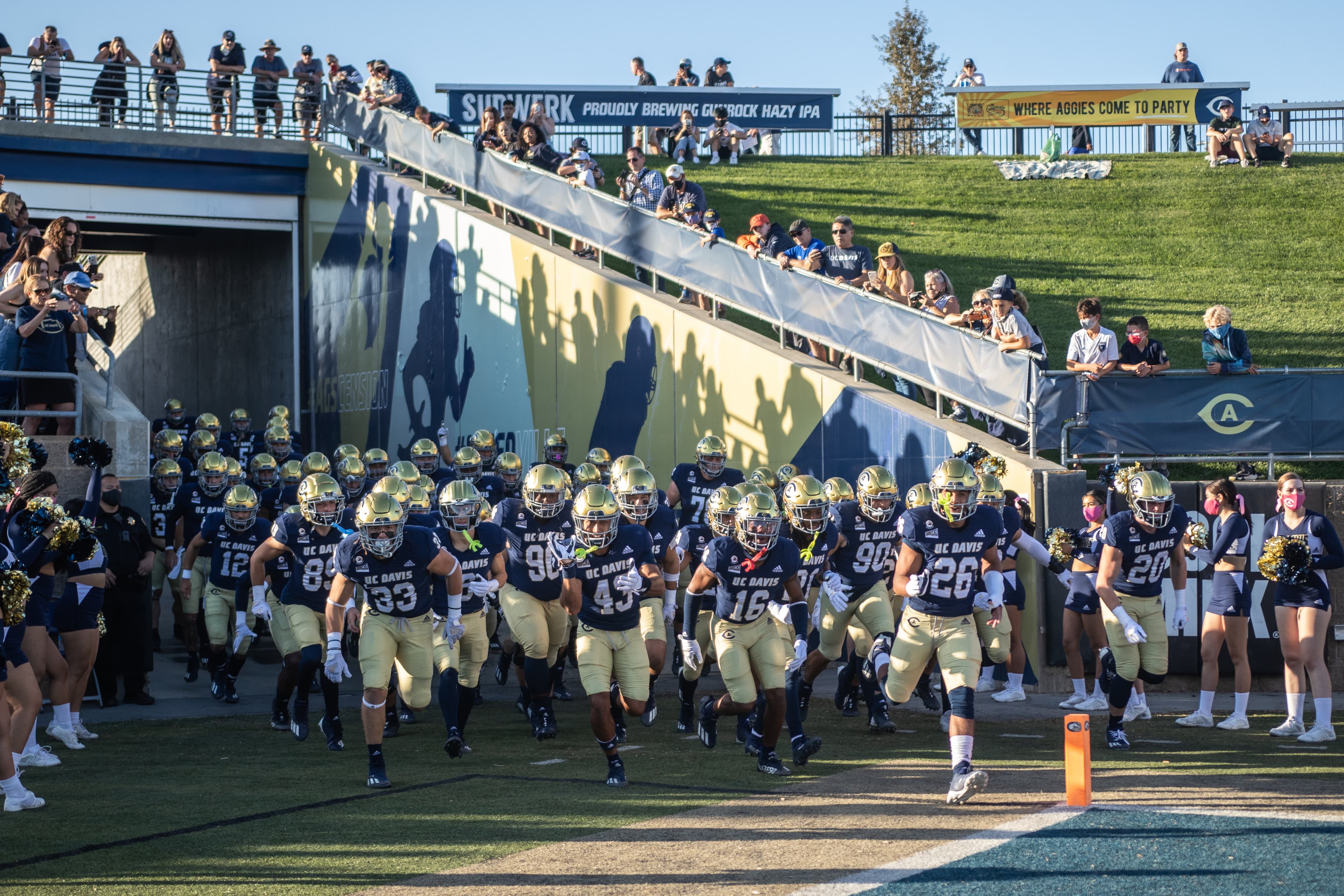 UC Davis Football team run into UC Davis Health Stadium