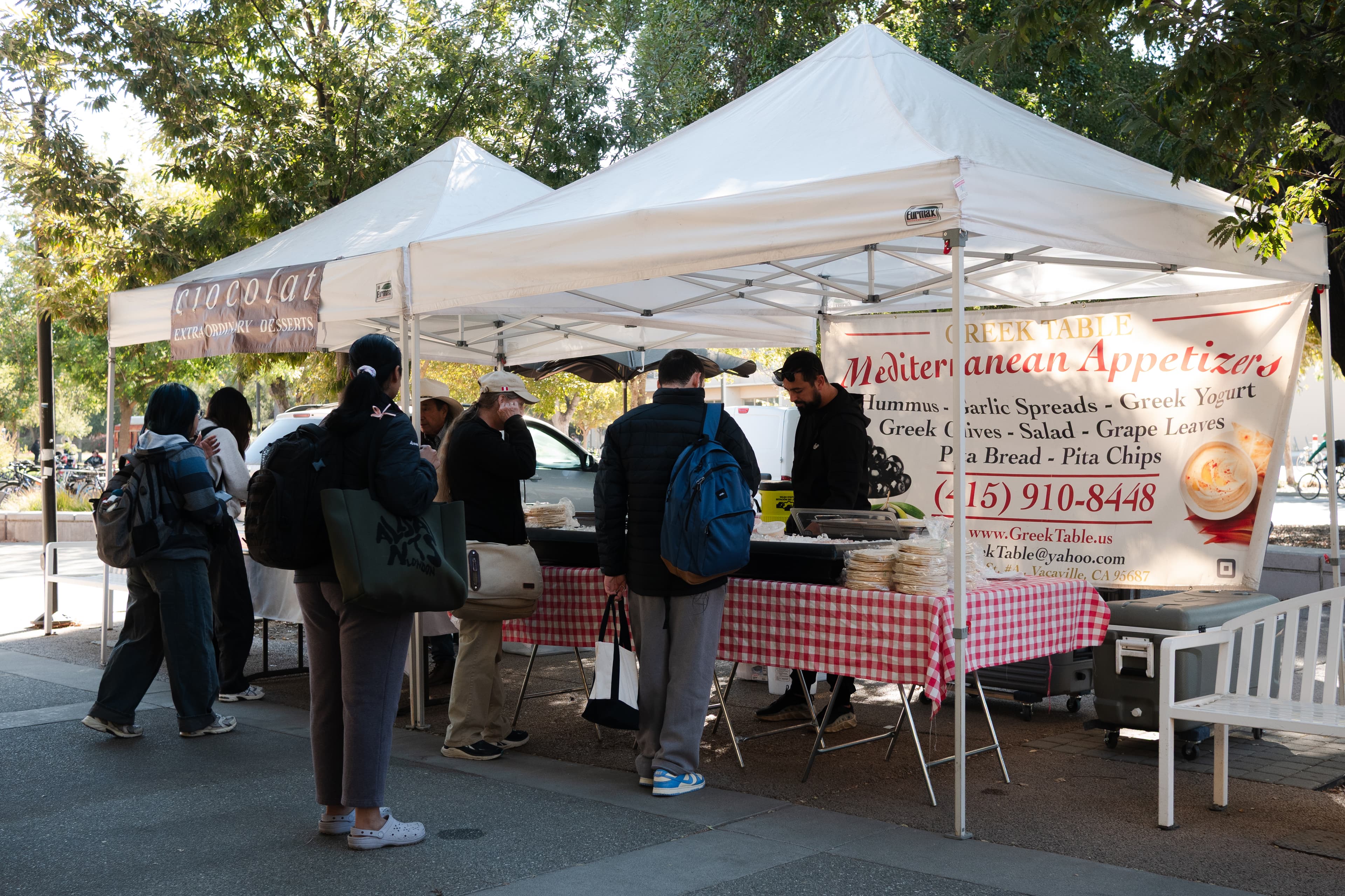 Students buy food from Greek Table at the on-campus farmers market on Wednesday, Oct. 14. (Jinni Huynh / Aggie)