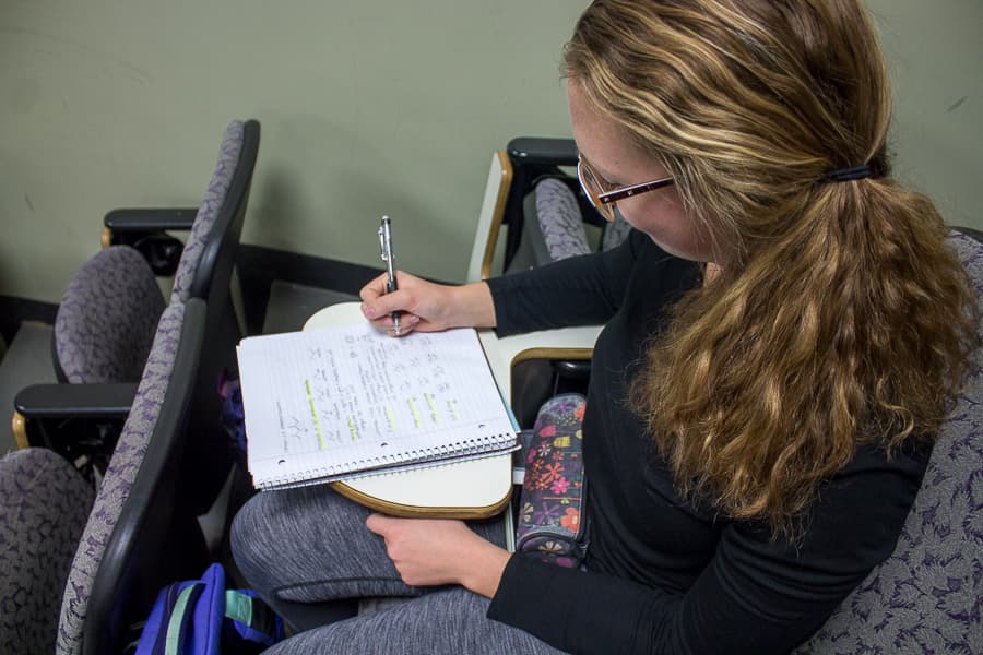 A woman with pen and paper taking an exam.