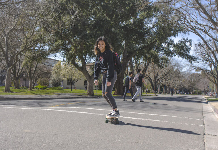 Skateboarders soar smoothly across campus
