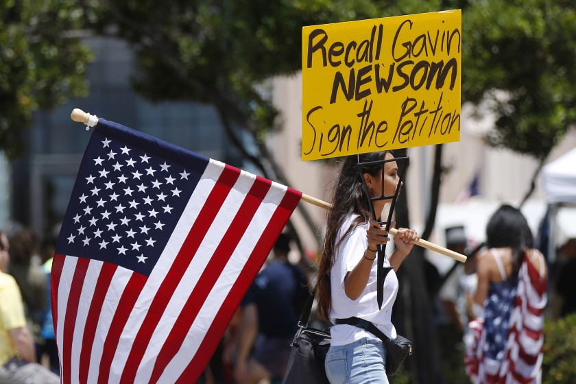 Photo of protesters holding signs to recall Gavin Newsom